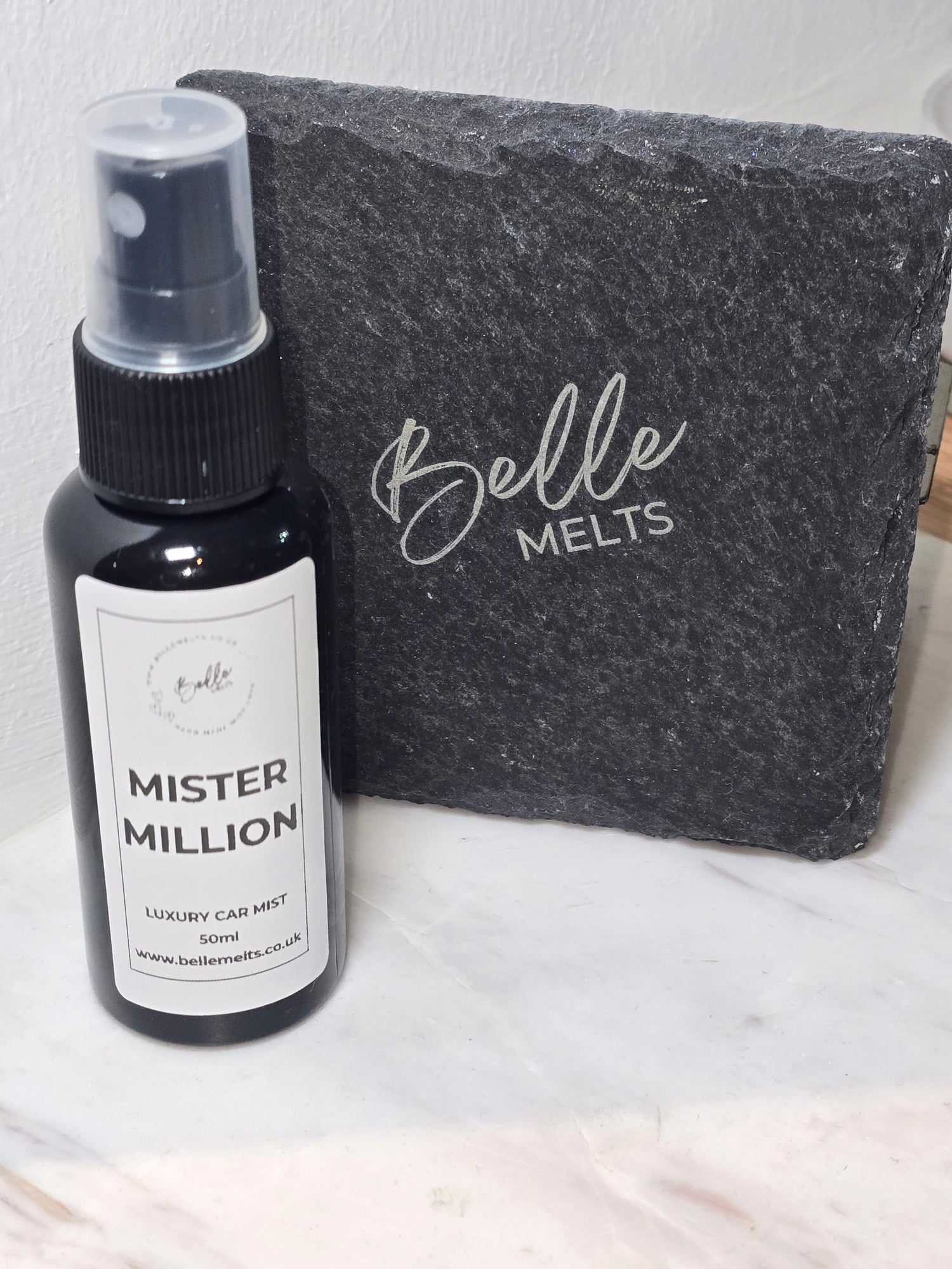 "Belle Melts Car Mist spray bottle displayed in a modern car interior, symbolizing fresh and inviting fragrance."