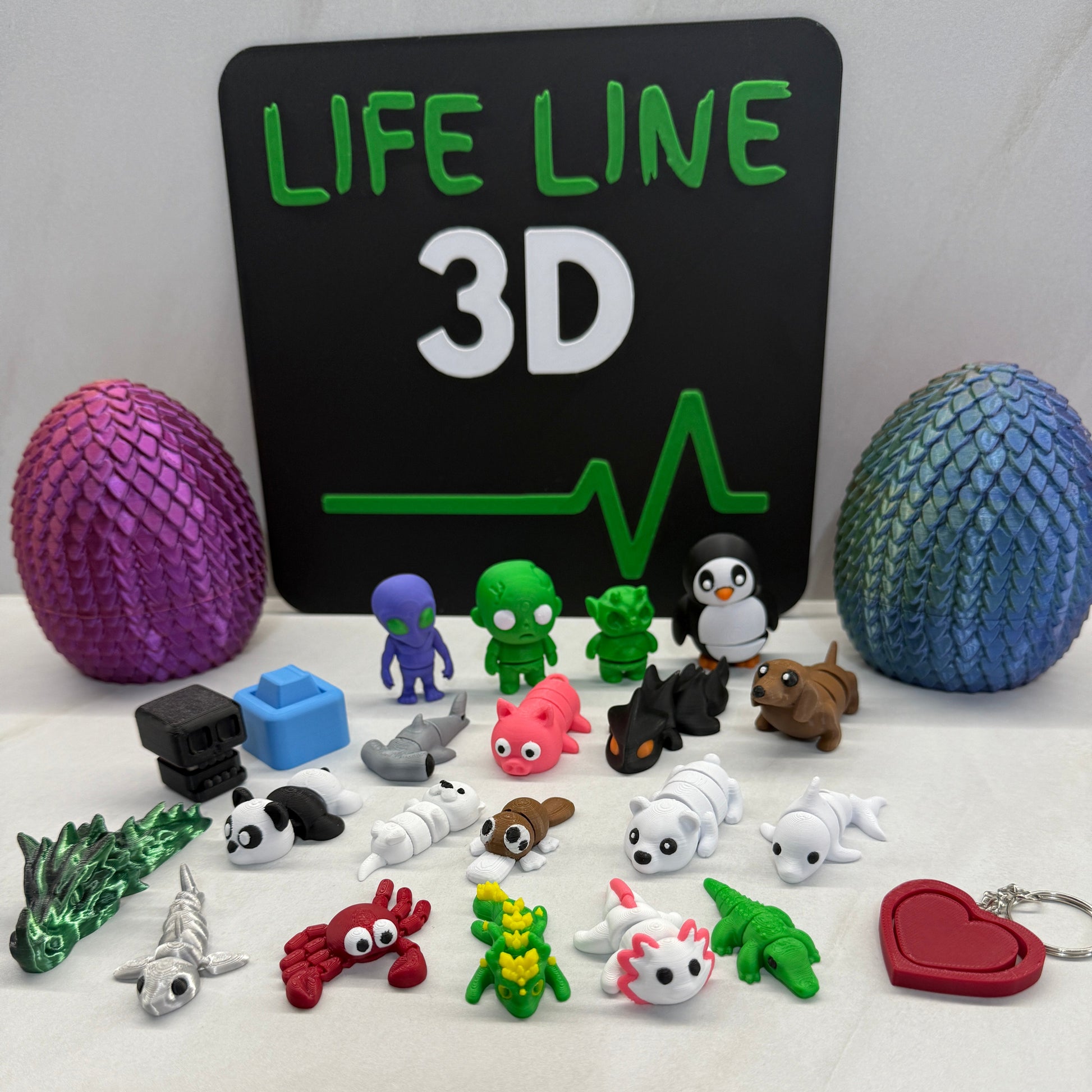 Collection of colorful 3D printed figurines and balls on a white background with 'Lifeline 3D' branding.