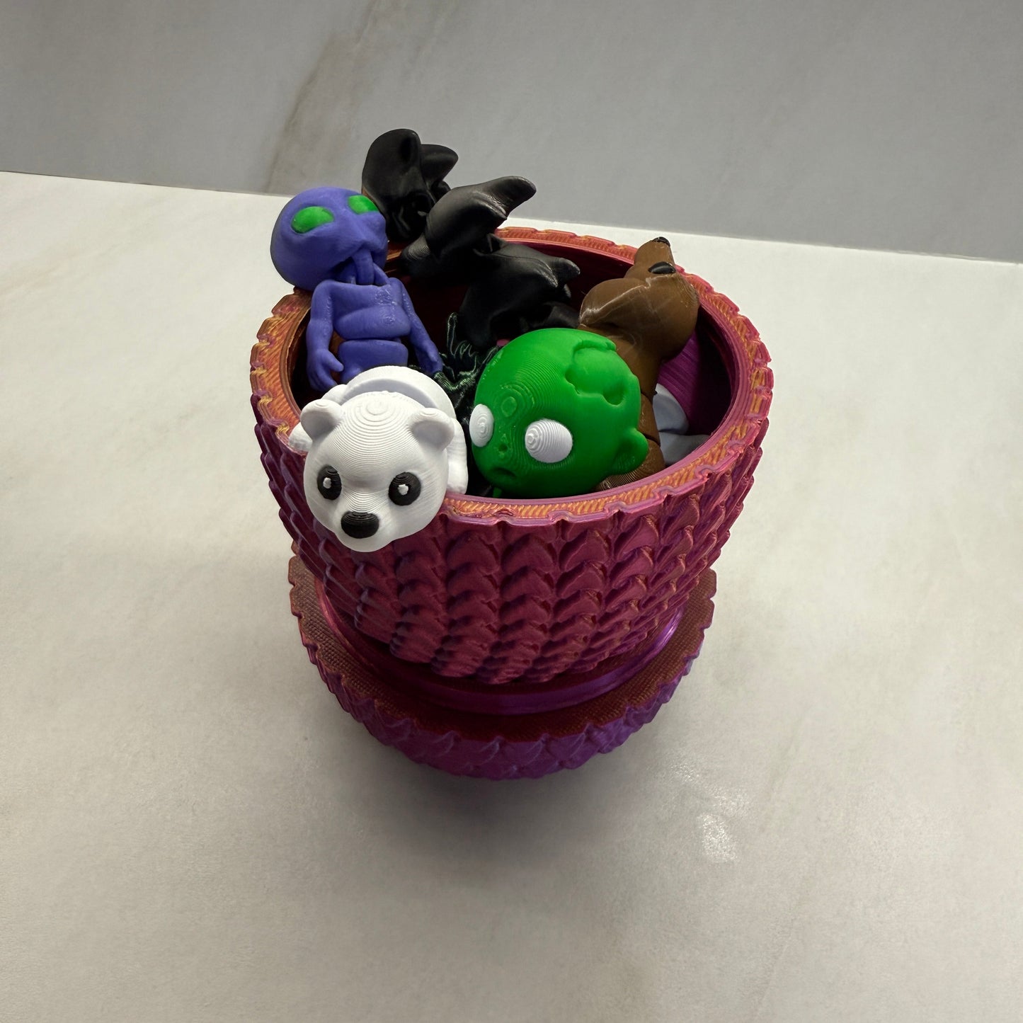 Small toy figure of a character with a purple hat on a light gray background