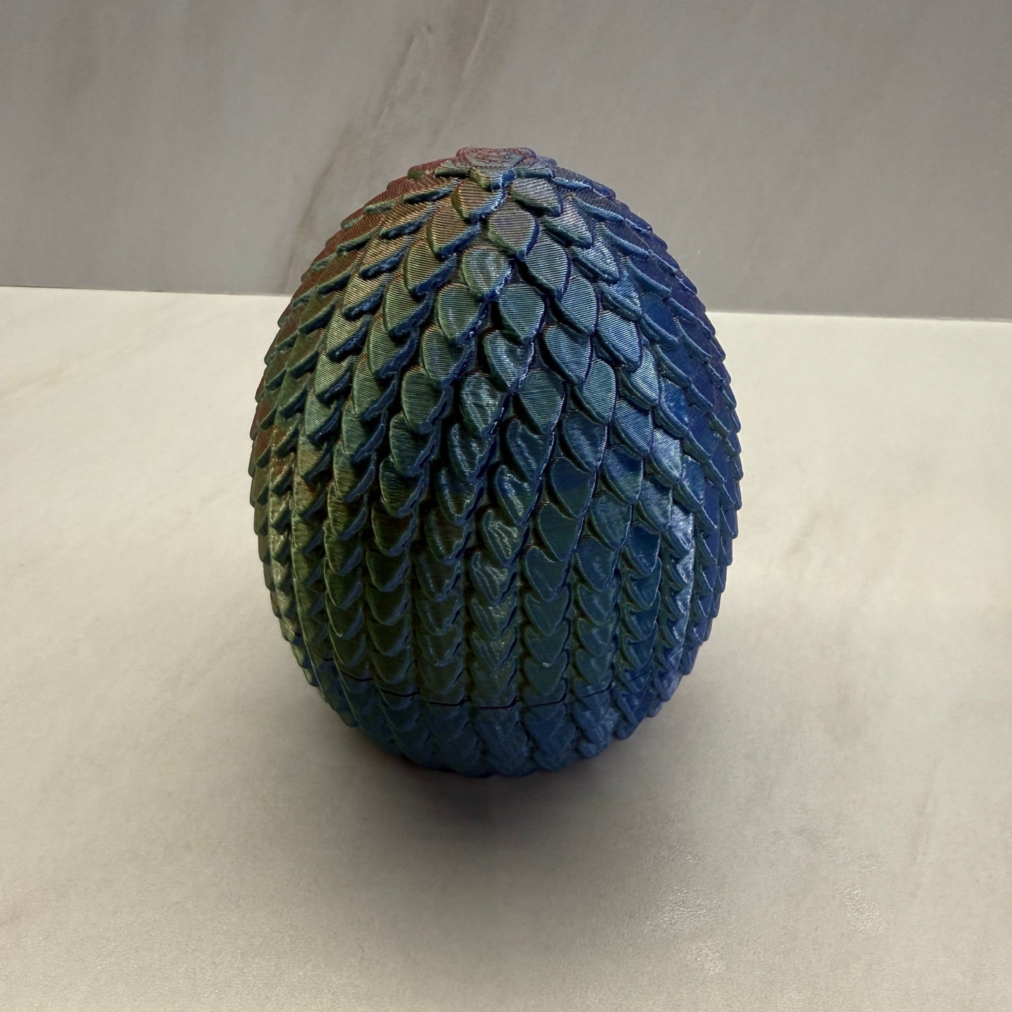 Textured blue and green ball on a beige background