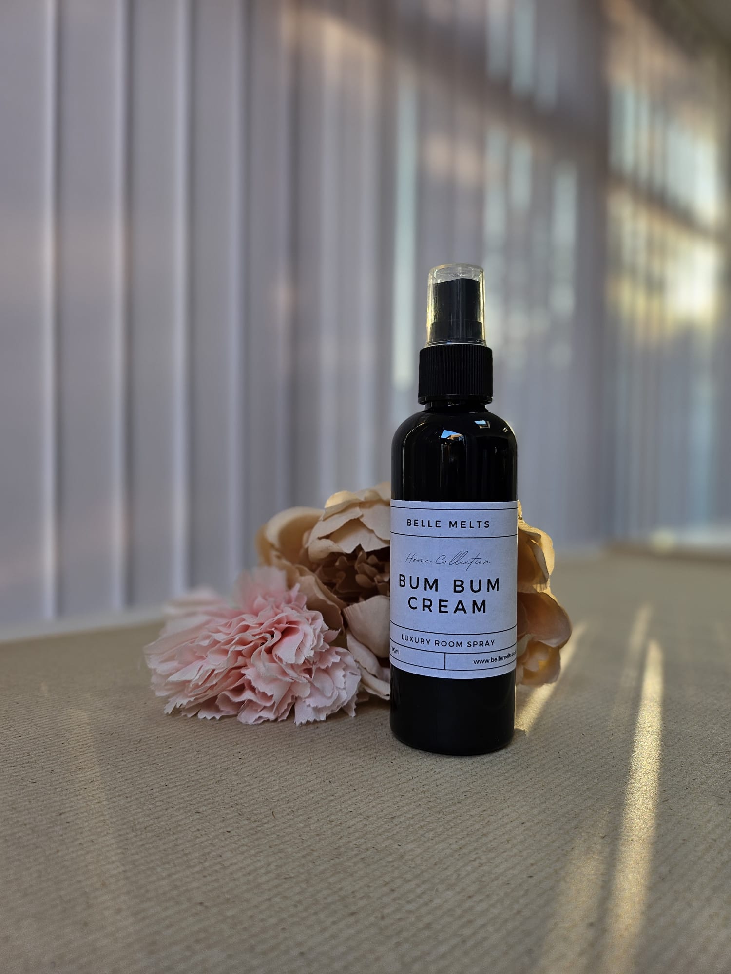 "Belle Melts Room & Linen Spray bottle with a fine mist, delivering refreshing home fragrance."