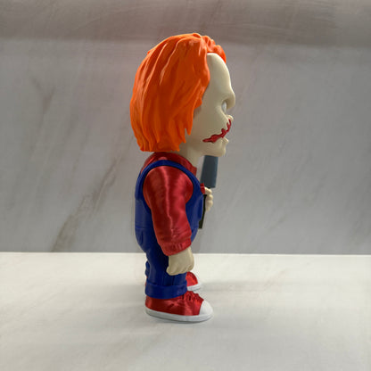 Superhero figurine with orange cape and blue suit against a plain background