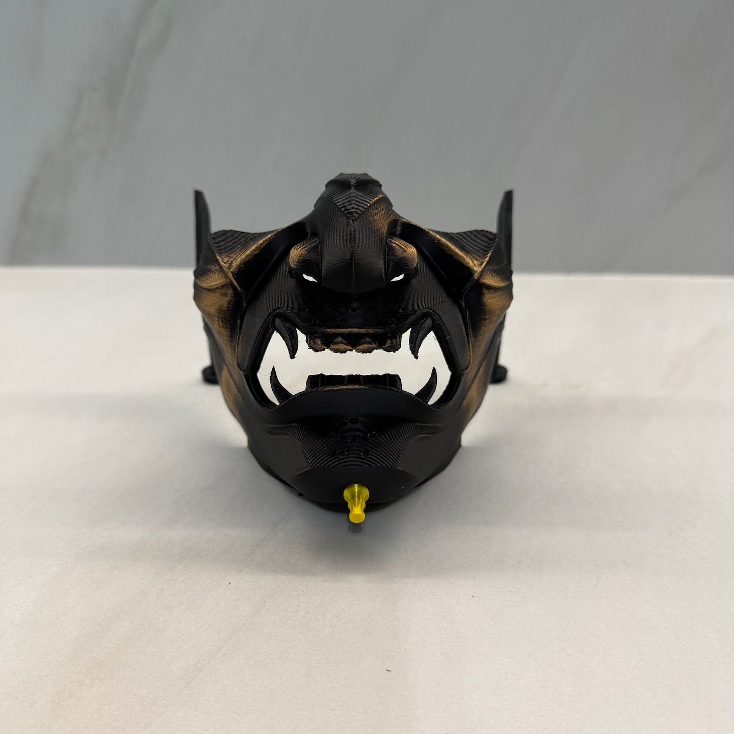 Black and gold mechanical component on a white background