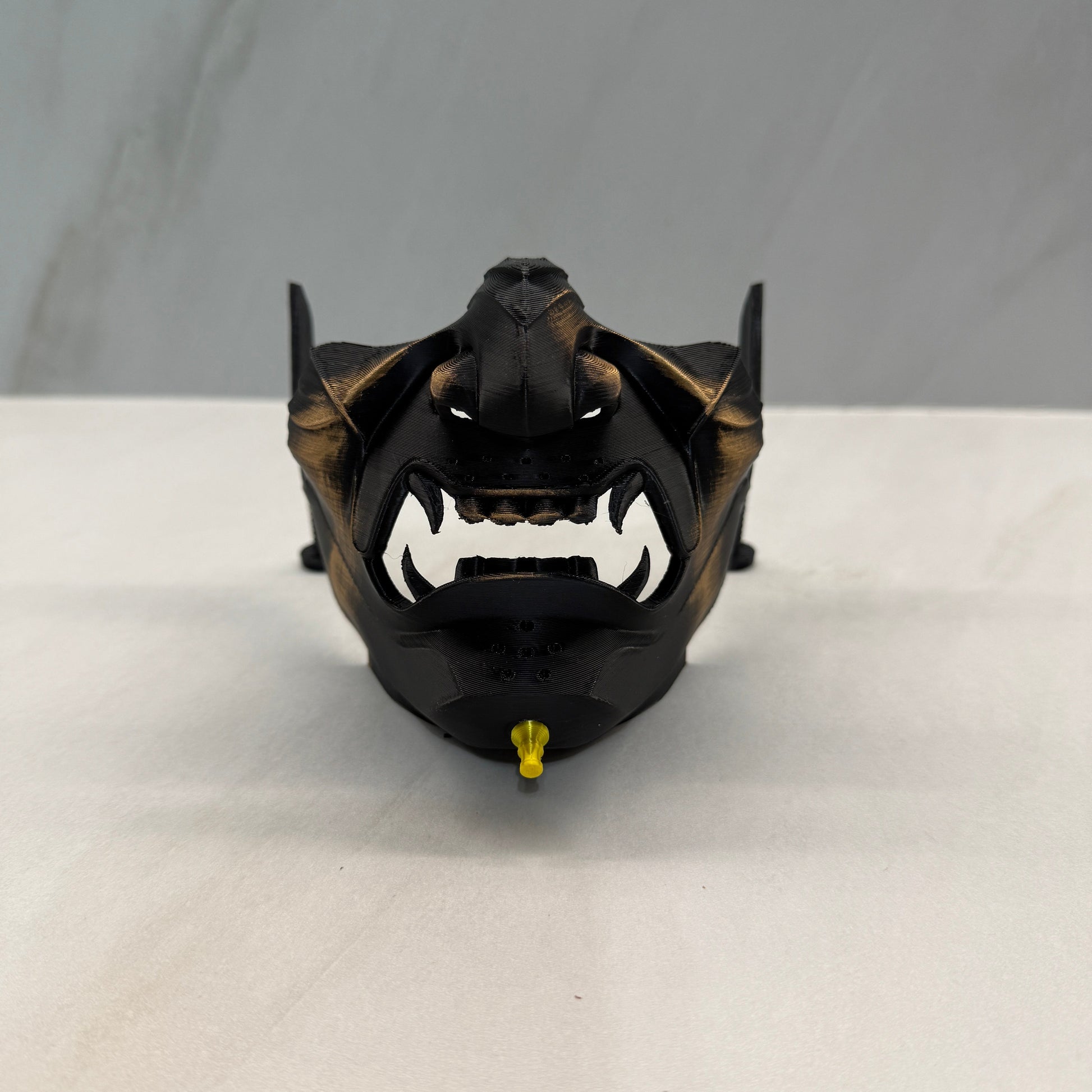 Black and gold mechanical component on a white background