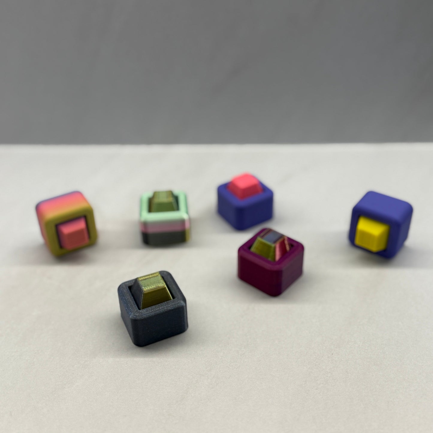 Colorful cube-shaped objects on a white surface with a gray background