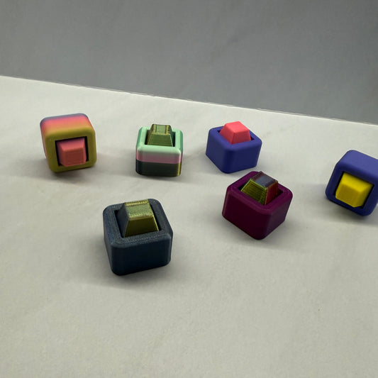 Colorful geometric block magnets on a white surface with a gray background - Send - Sensory - Fidget - Clicker