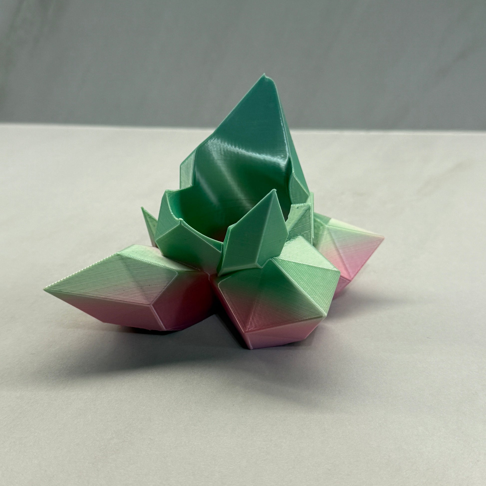 Geometric flower sculpture in pastel colors on a neutral background