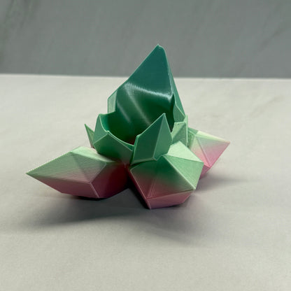 Geometric flower sculpture in pastel colors on a neutral background