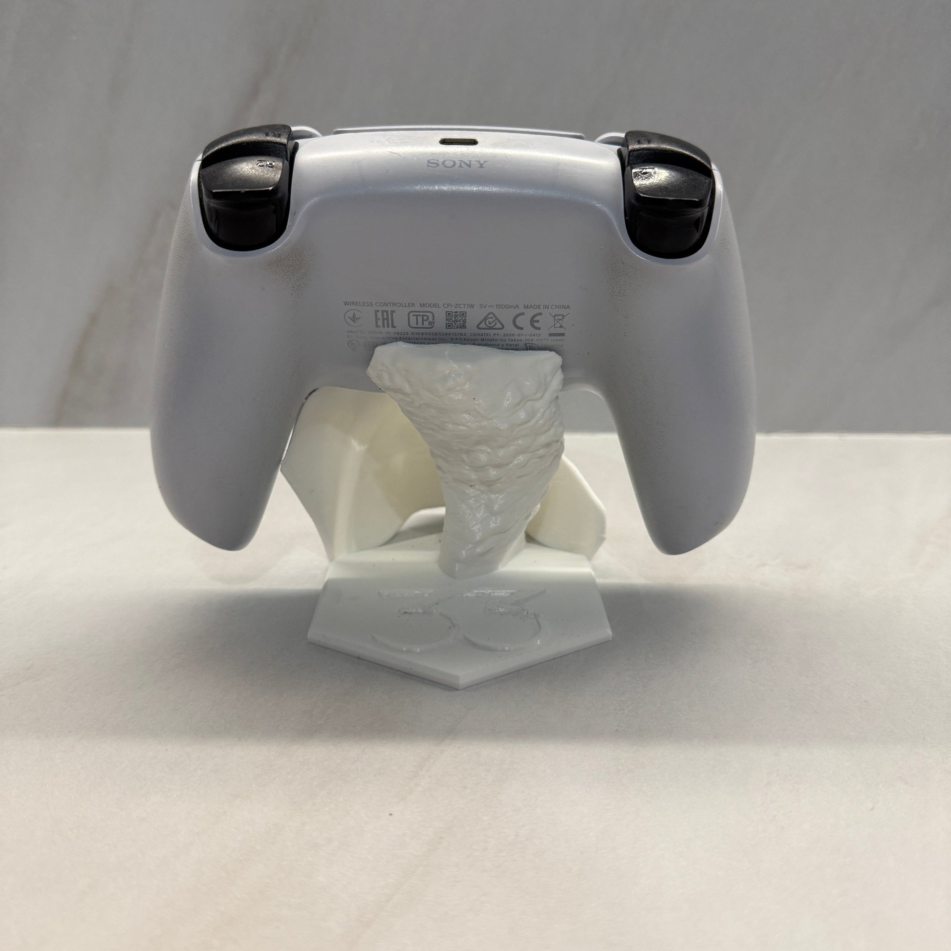 Handheld device with a white cloth attached to it on a light gray background