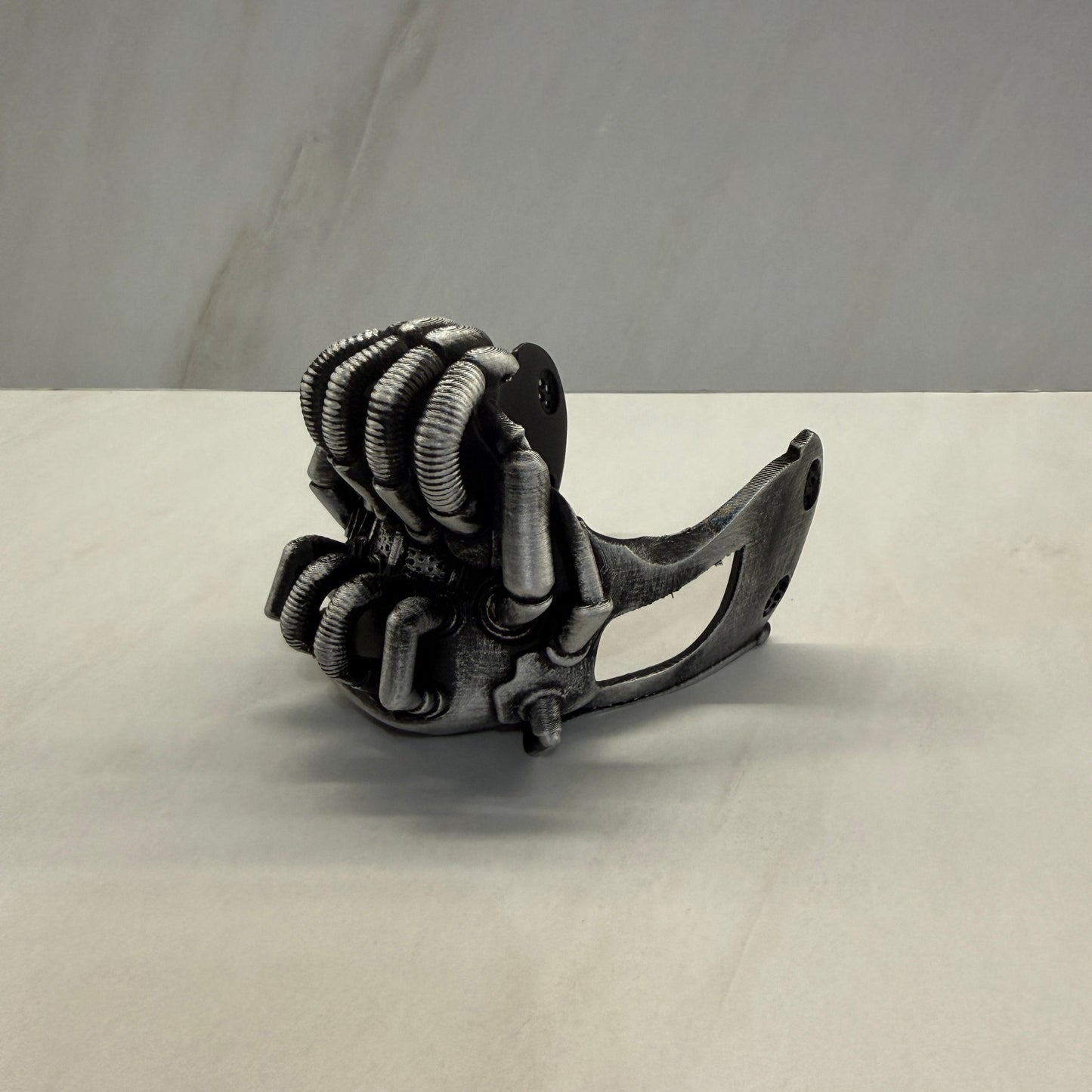 Metal clasp with a rope tied around it on a plain background