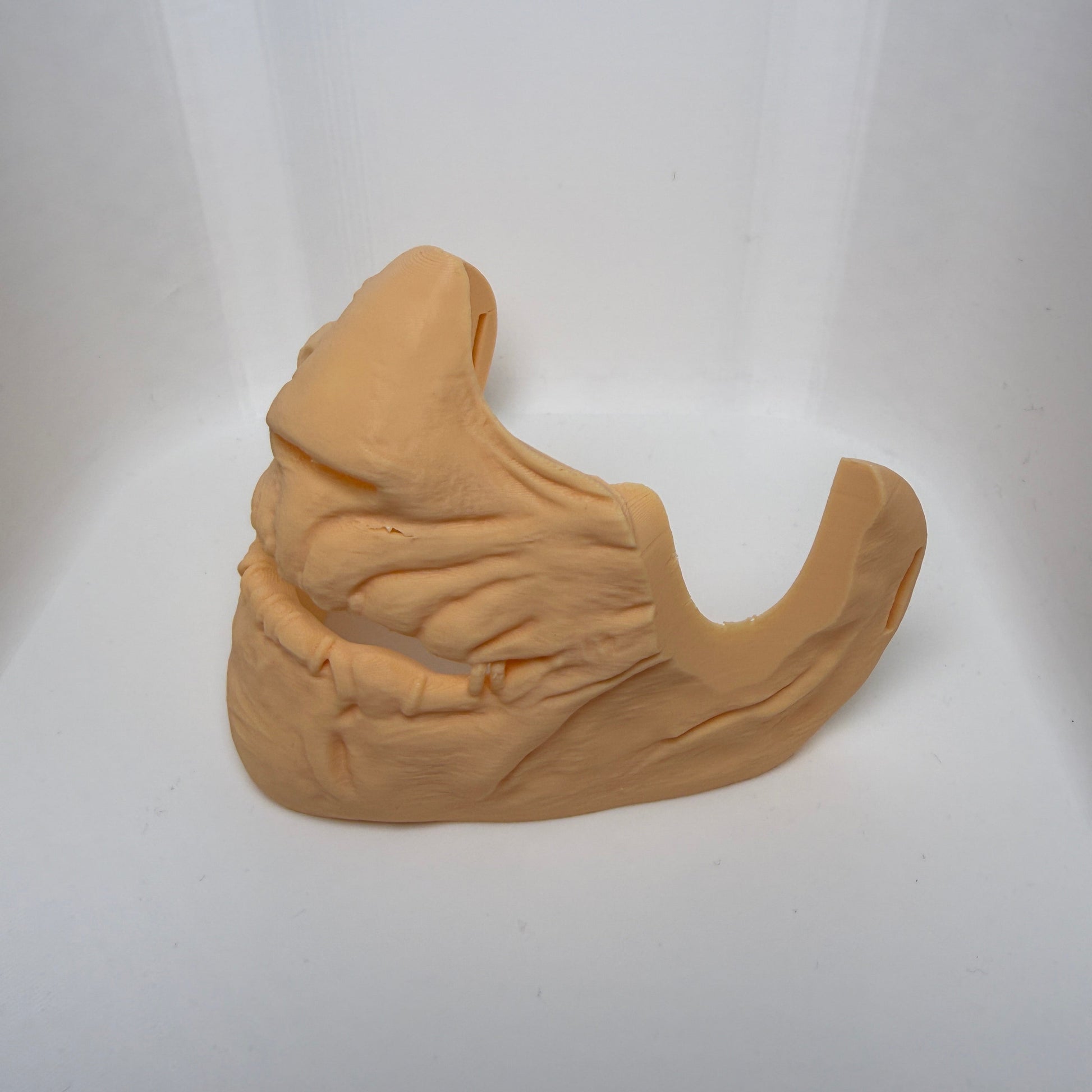 Beige silicone mold shaped like a banana on a white background