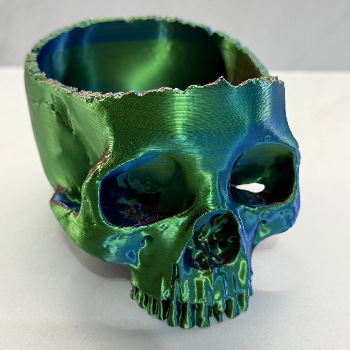 Green ceramic vase with textured surface on a white background