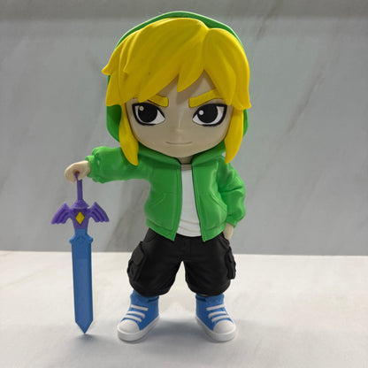 Toy figure of a character with blonde hair, green jacket, and black pants holding a sword on a white background