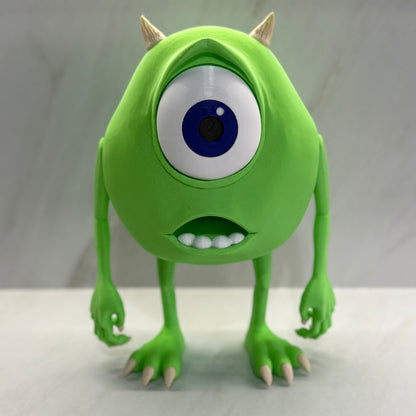 Green monster toy with a large blue eye on a white background