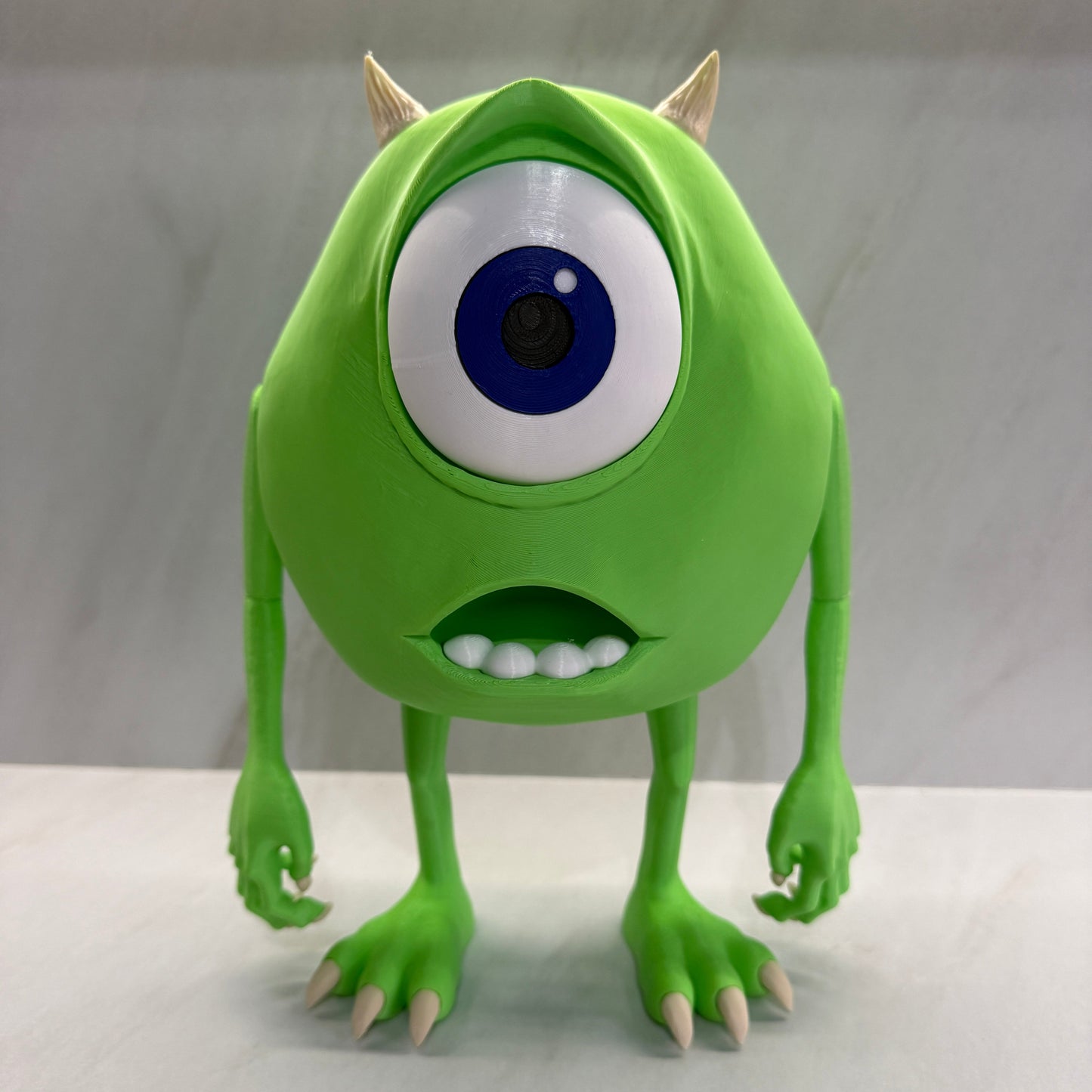 Green monster toy with one eye and spikes on a white background