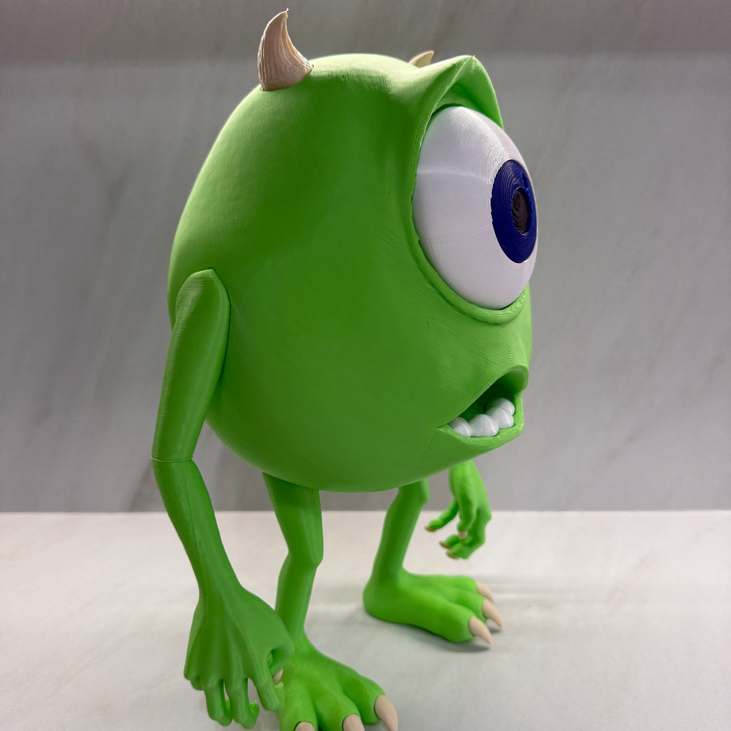 Green cartoon character with one eye peering around a corner