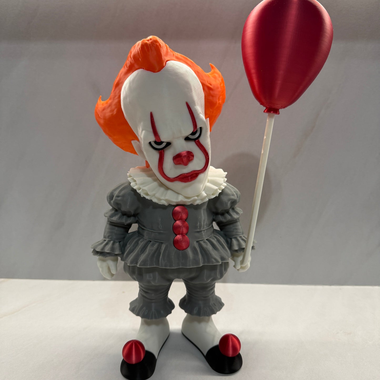 Clown figurine with red balloon on a white background