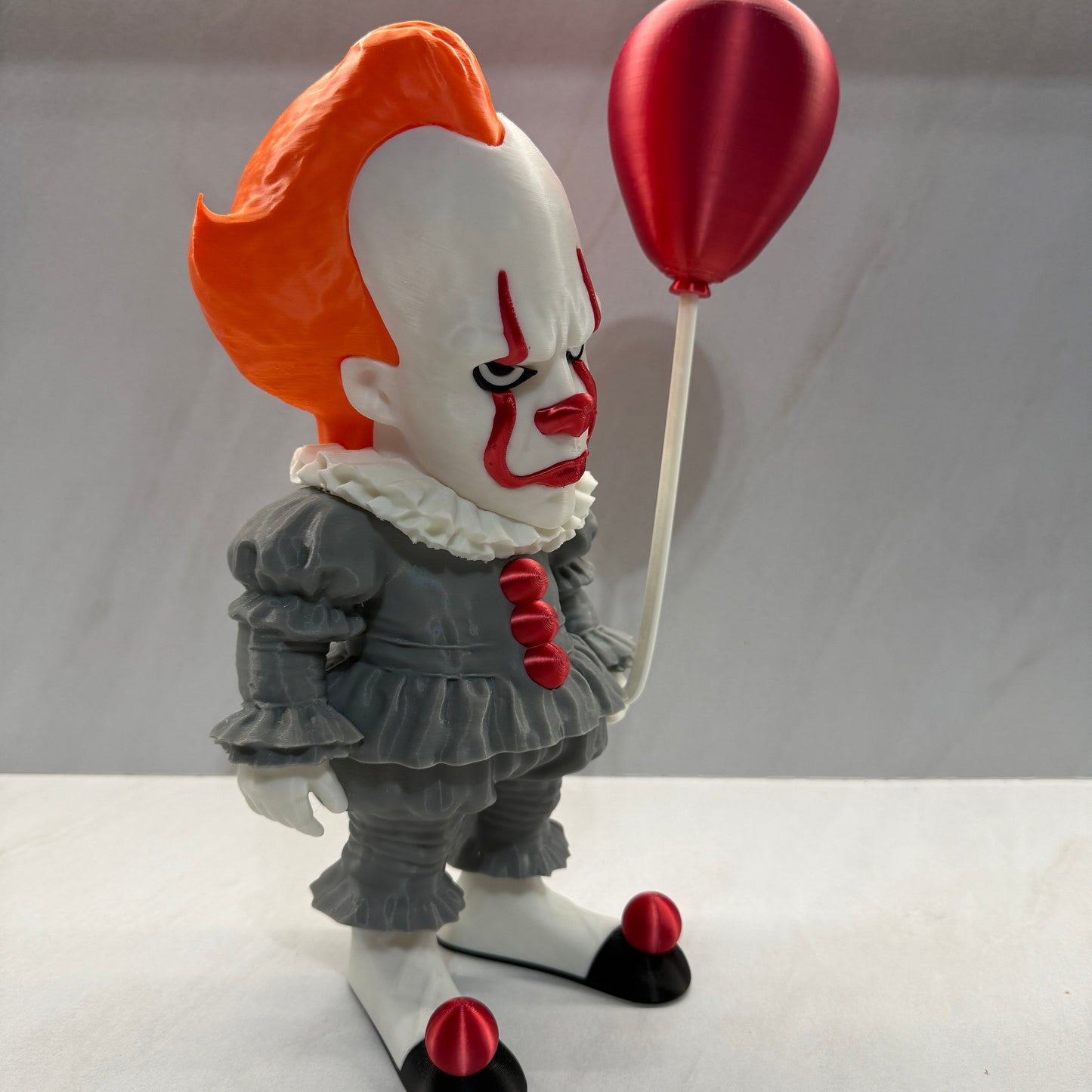 Clown figurine with a red balloon on a white background