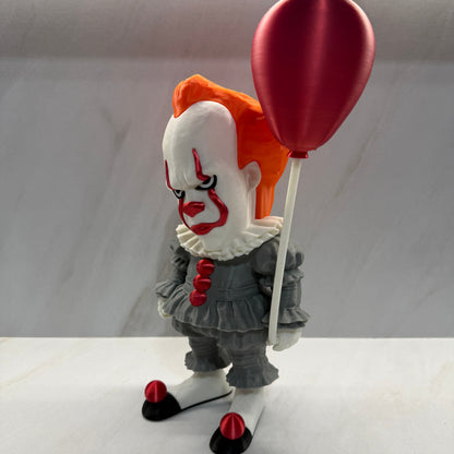 Clown figurine with a red balloon on a white background