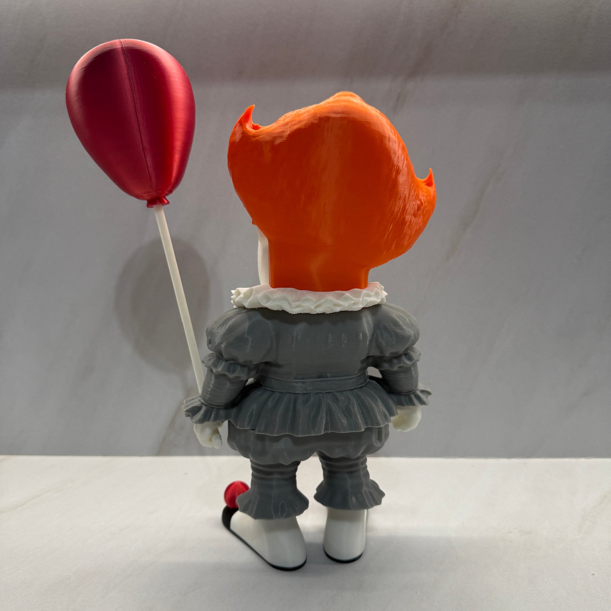Small figure with an orange head and gray body on a white background