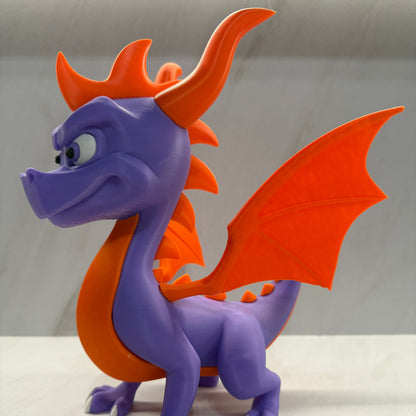Purple and orange dragon-like creature toy on a plain background